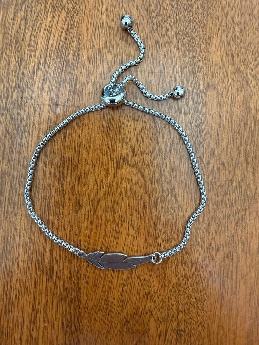 Silver feather design bracelet with slide adjustable latch from Ivy's Gifts & Boutique, featuring elegant feather charms on a sleek silver band.