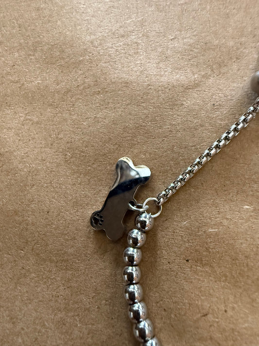 Silver dog bone charm bracelet with adjustable slide closure, featuring Ivy's Gifts & Boutique branding and detailed bone charm.
