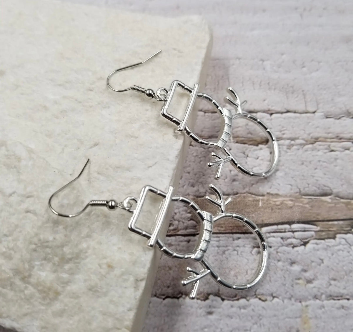 Silver snowman silhouette earrings with a 3D design, featuring festive holiday charm, ideal for winter and Christmas accessories.