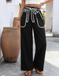 Black straight pants with white stitched front pockets and a tie belt from Ivy's Gifts & Boutique.