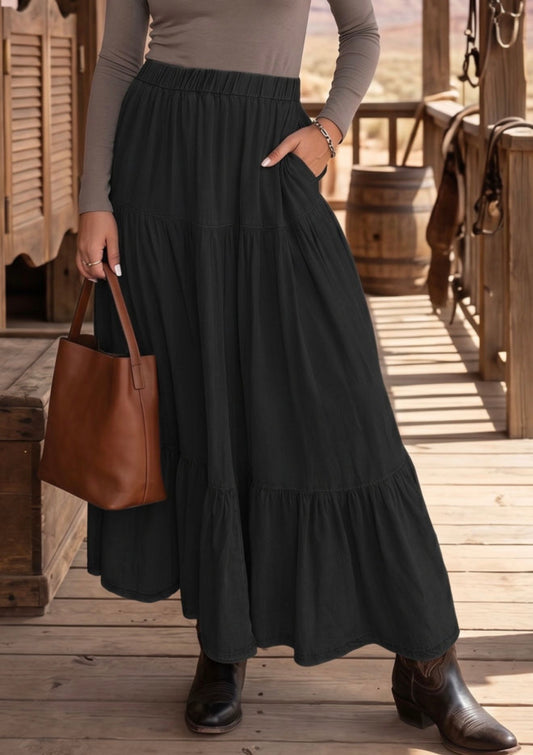 Black tiered hem maxi skirt by Ivy's Gifts & Boutique featuring an elastic waistband and flowing fabric.