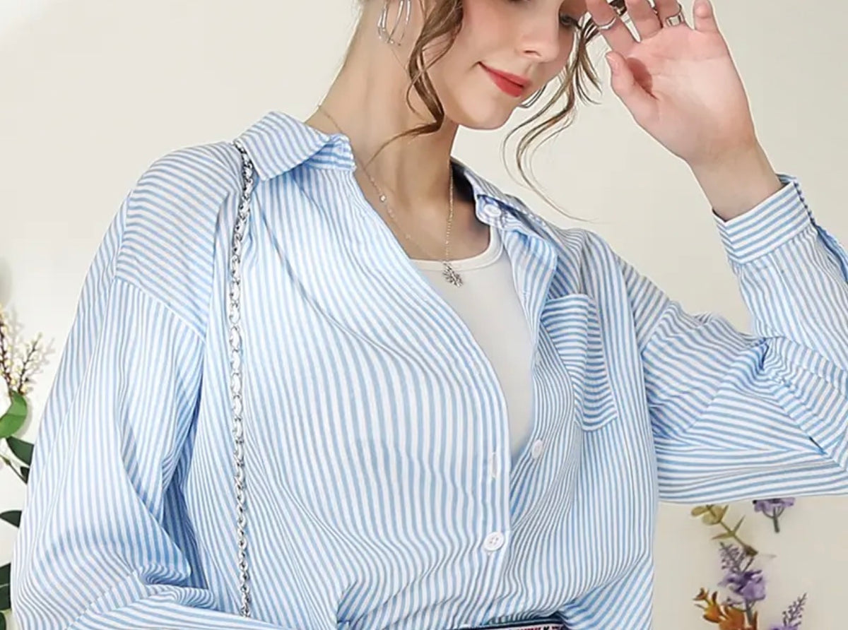 Blue striped button-up blouse by Ivy's Gifts & Boutique, showcasing a versatile, stylish women's top with a classic fit and collar.