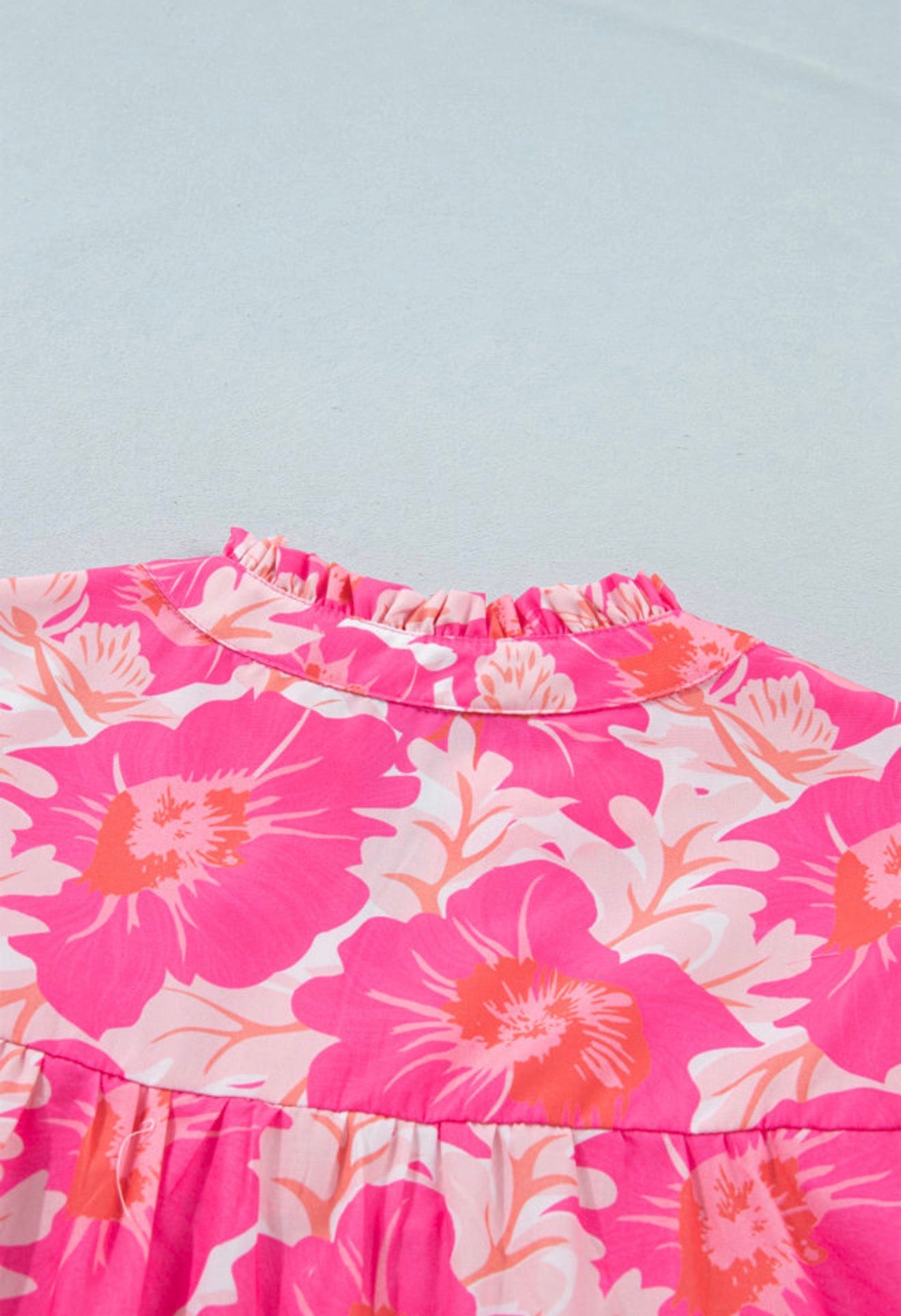 Pink and orange floral bubble sleeve summer top by Ivy's Gifts & Boutique, featuring short sleeves and vibrant floral pattern.