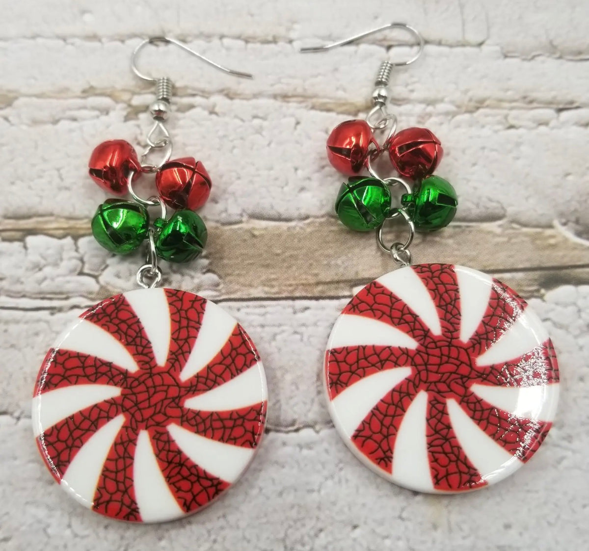 Ivy's Gifts & Boutique peppermint candy disc earrings with red and white striped design, hanging on silver hooks.