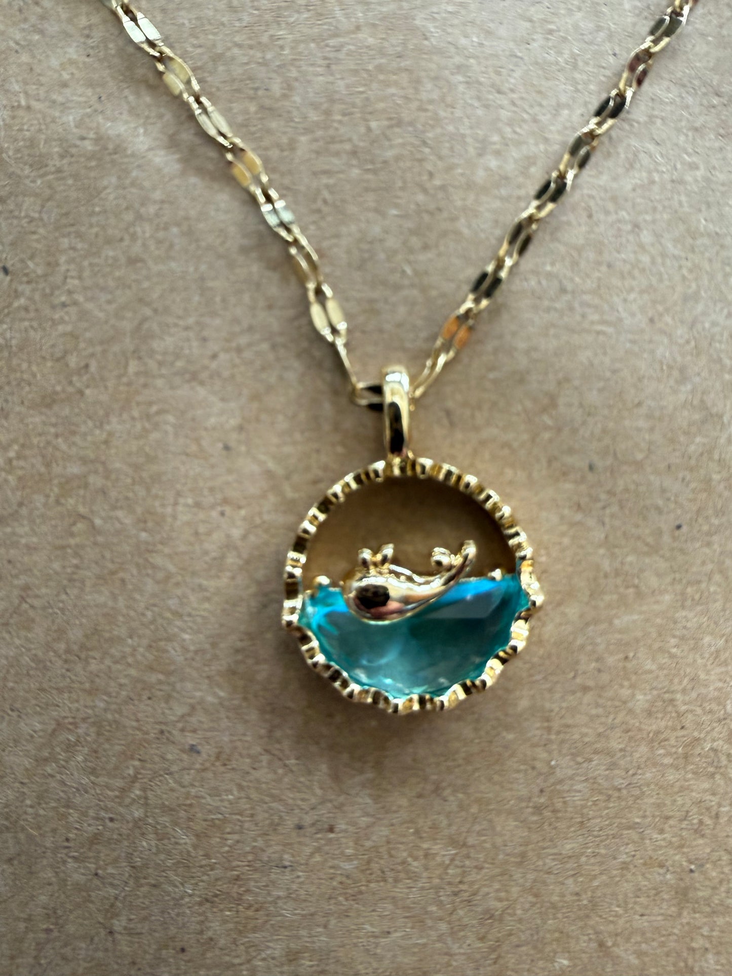 Gold dolphin necklace with acrylic blue water detail, round pendant, from Ivy's Gifts & Boutique.
