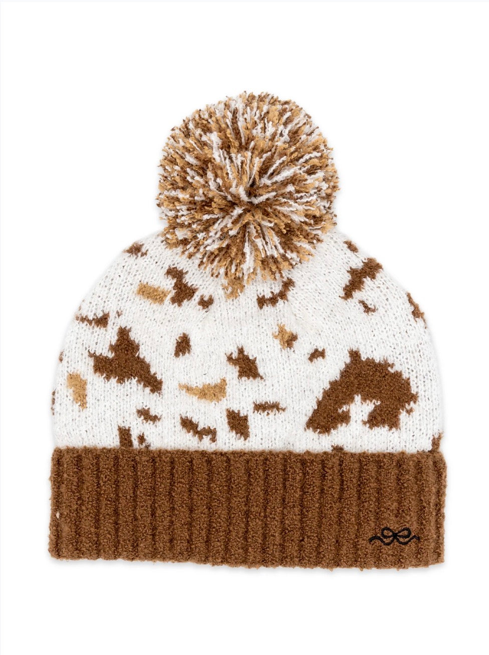 Ivy's Gifts & Boutique cow print beanie with fluffy ball top, cozy knit hat featuring black and white cow pattern and pom-pom on top.