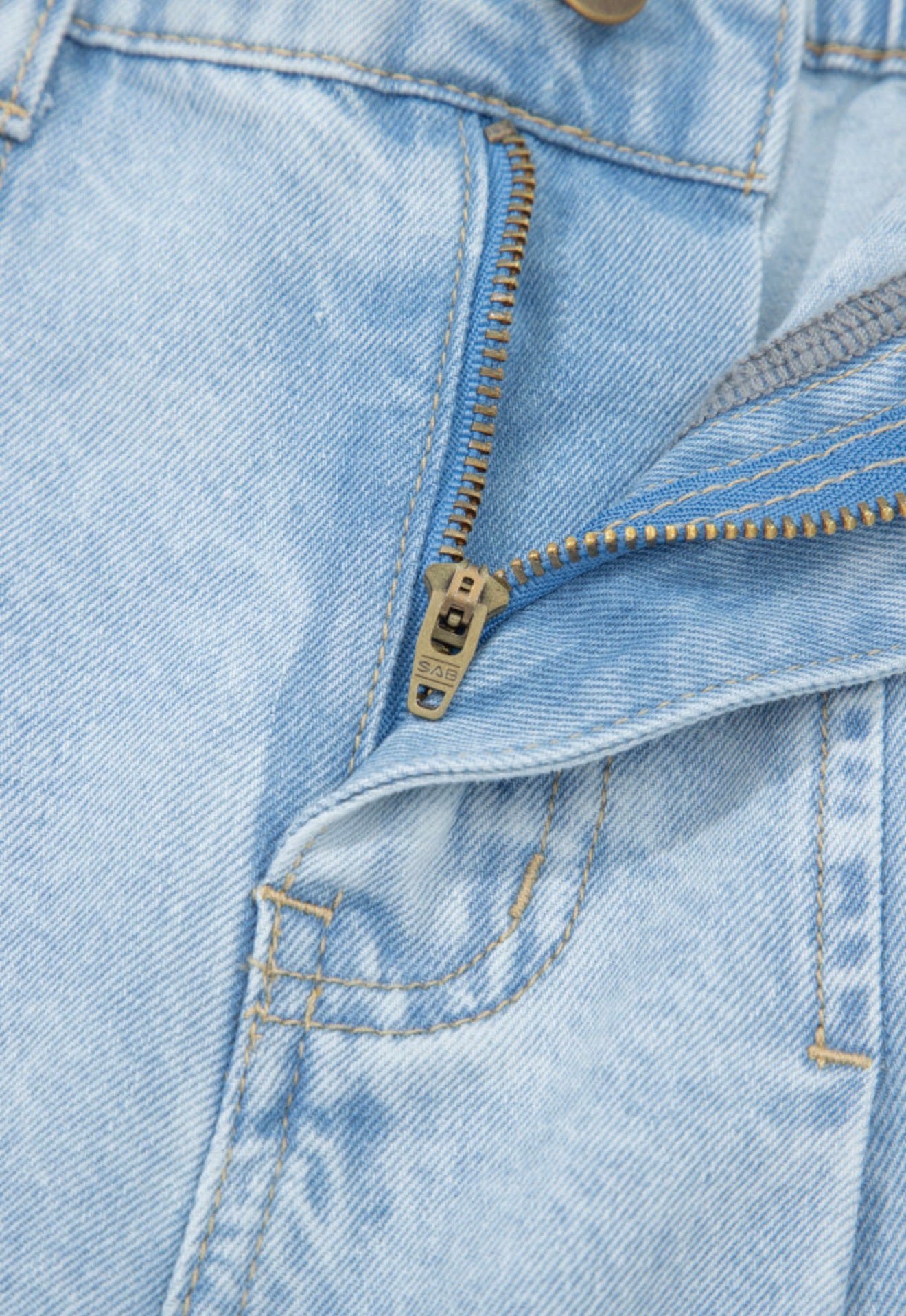 Light wash wide leg jeans by Ivy's Gifts & Boutique with frayed hems, side splits, and studded accents.
