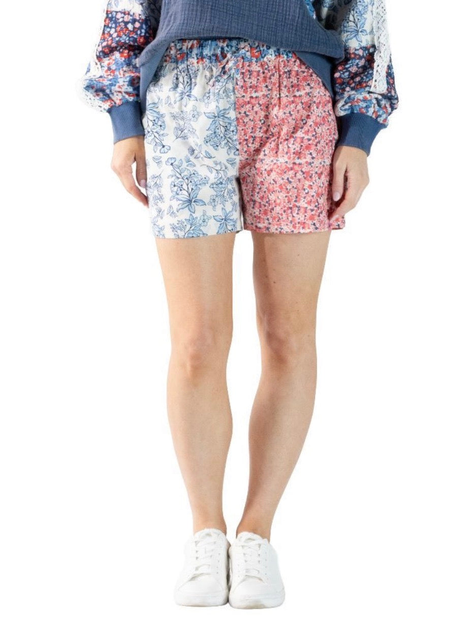 Red, white, and blue patchwork block style shorts by Ivy's Gifts & Boutique, featuring colorful fabric panels and casual fit.