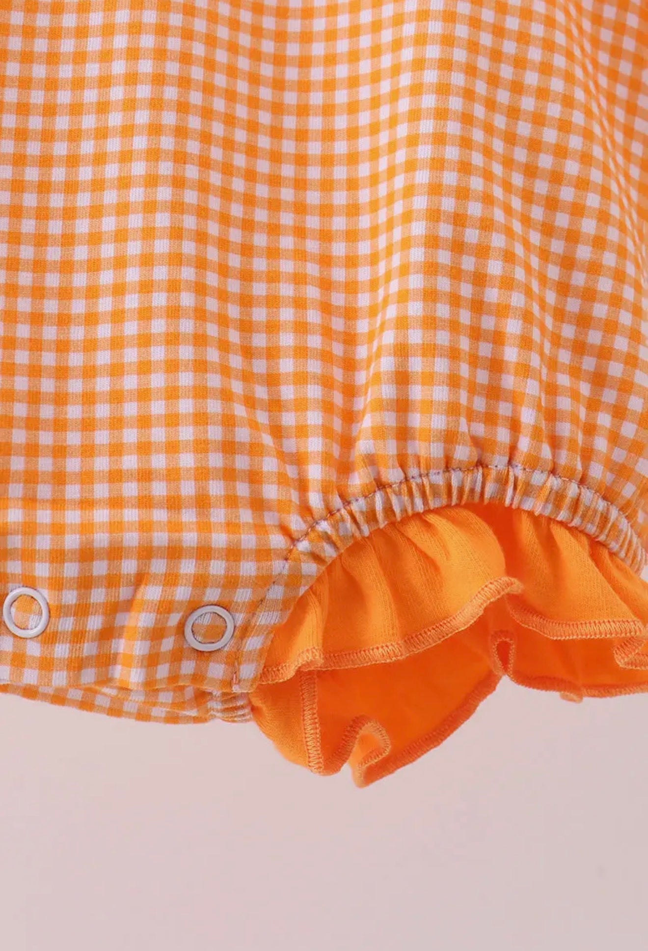 Long sleeve orange and white gingham bubble with embroidery by Ivy's Gifts & Boutique, featuring a classic checkered pattern and decorative stitching.