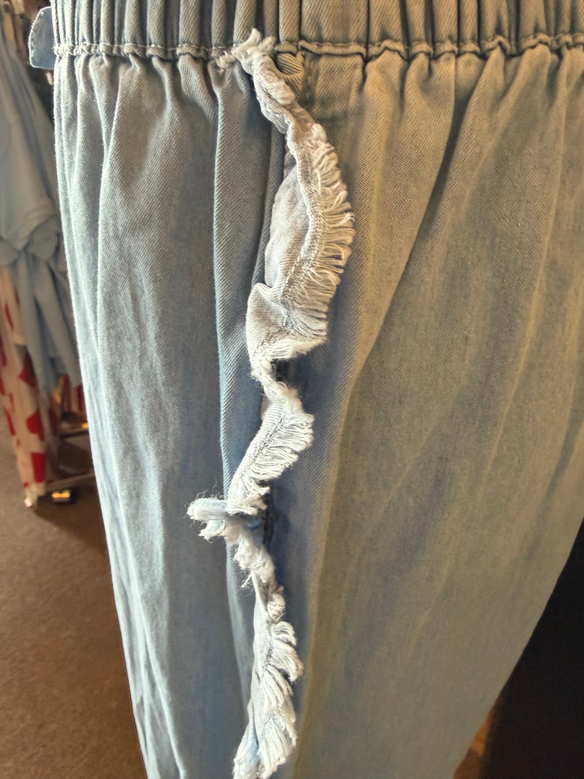 Lightweight denim shorts with frayed edges, elastic drawstring waist, from Ivy's Gifts & Boutique.