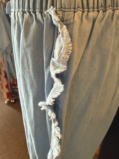 Lightweight denim shorts with frayed edges, elastic drawstring waist, from Ivy's Gifts & Boutique.