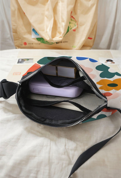 Cute flower-printed vinyl crossbody bag by Ivy's Gifts & Boutique, featuring a compact design with colorful floral patterns.