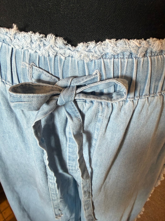 Lightweight denim pants with frayed edge elastic drawstring waist, featuring a relaxed fit and casual style from Ivy's Gifts & Boutique.