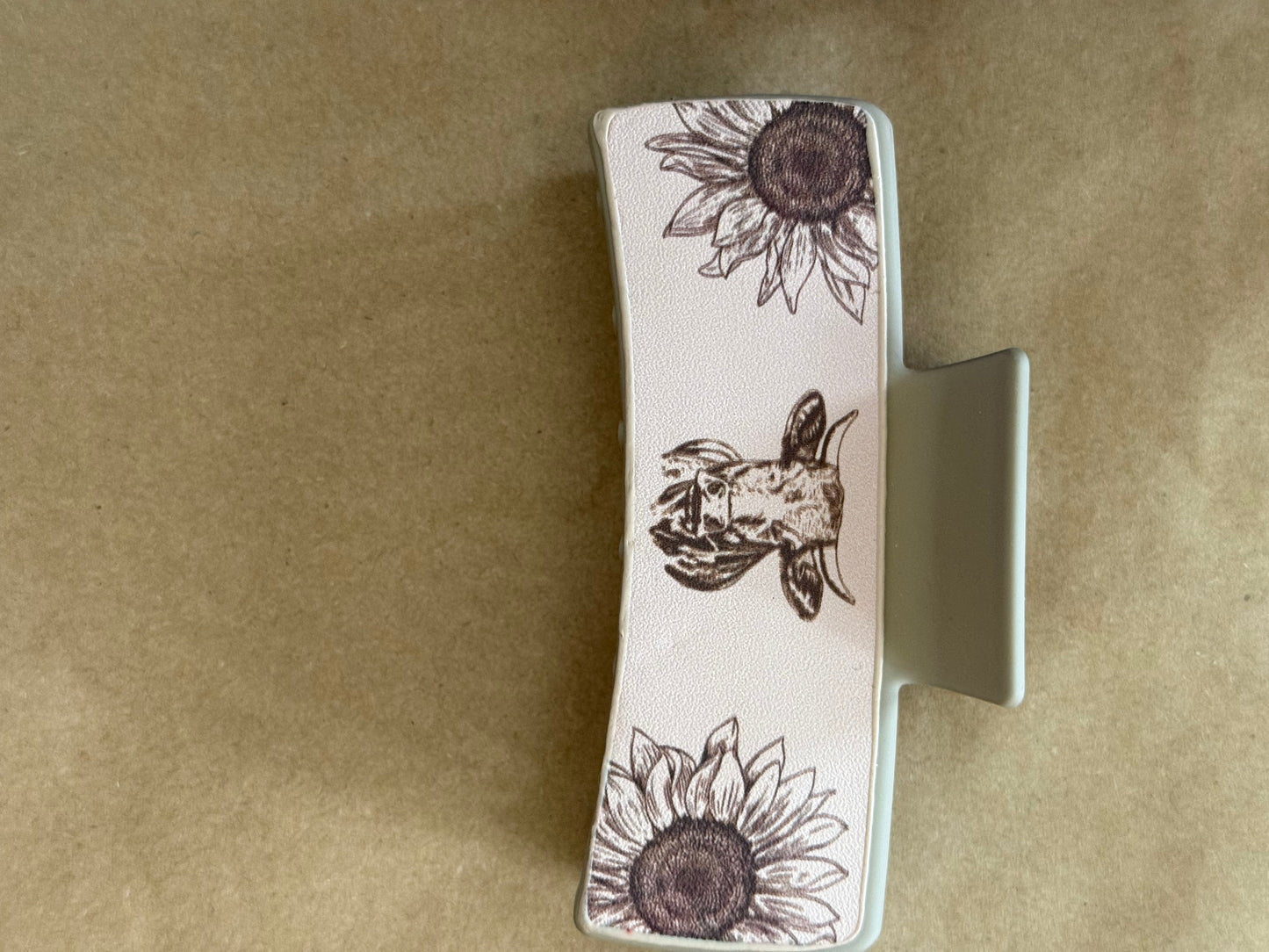 Leatherette sunflower claw clip by Ivy's Gifts & Boutique, showcasing a decorative yellow sunflower design and strong hair grip.