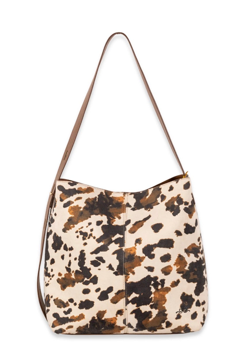 Cow print suede shoulder bag with adjustable strap and magnetic snap closure from Ivy's Gifts & Boutique.