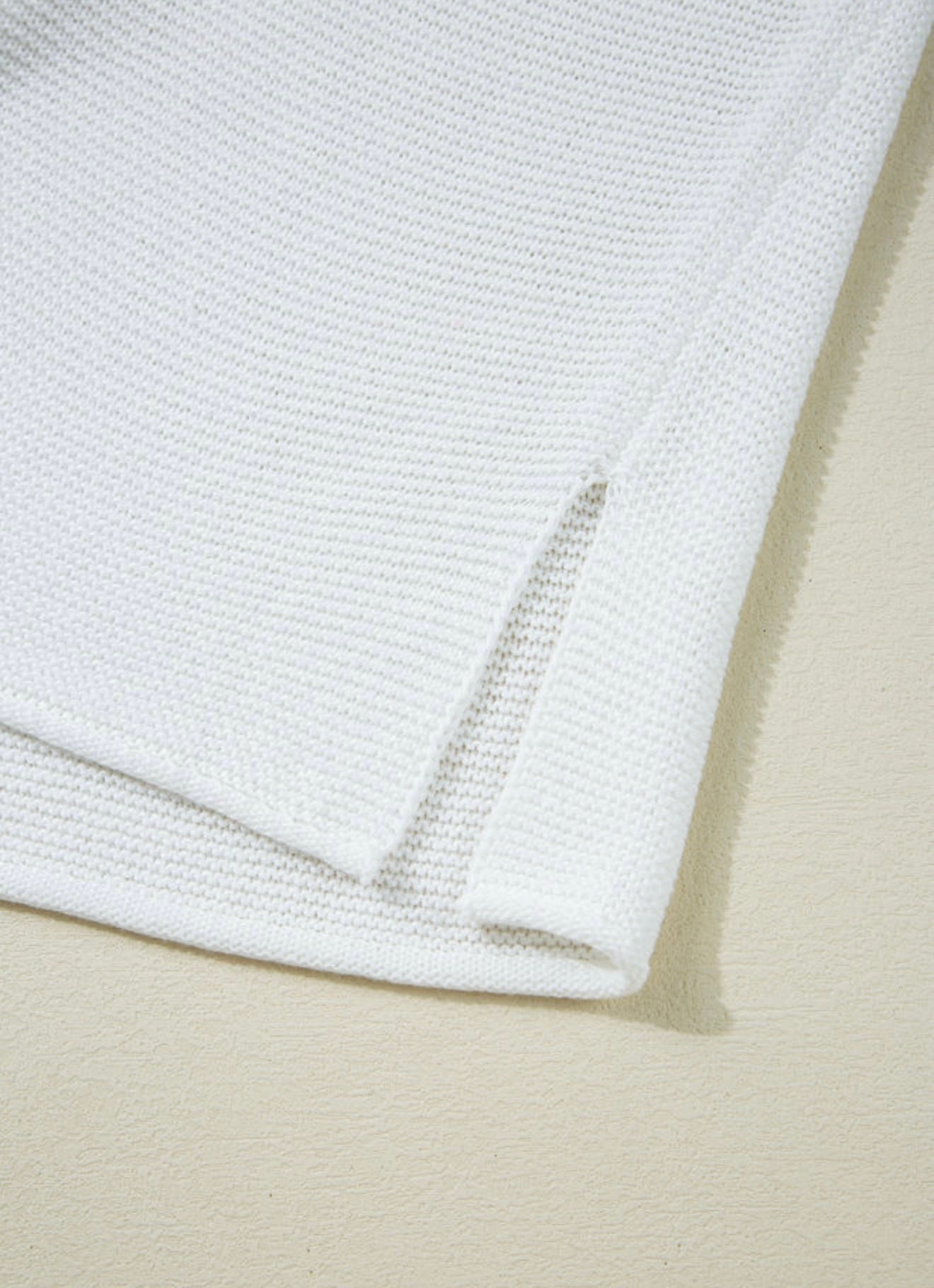 White sleeveless sweater with side splits