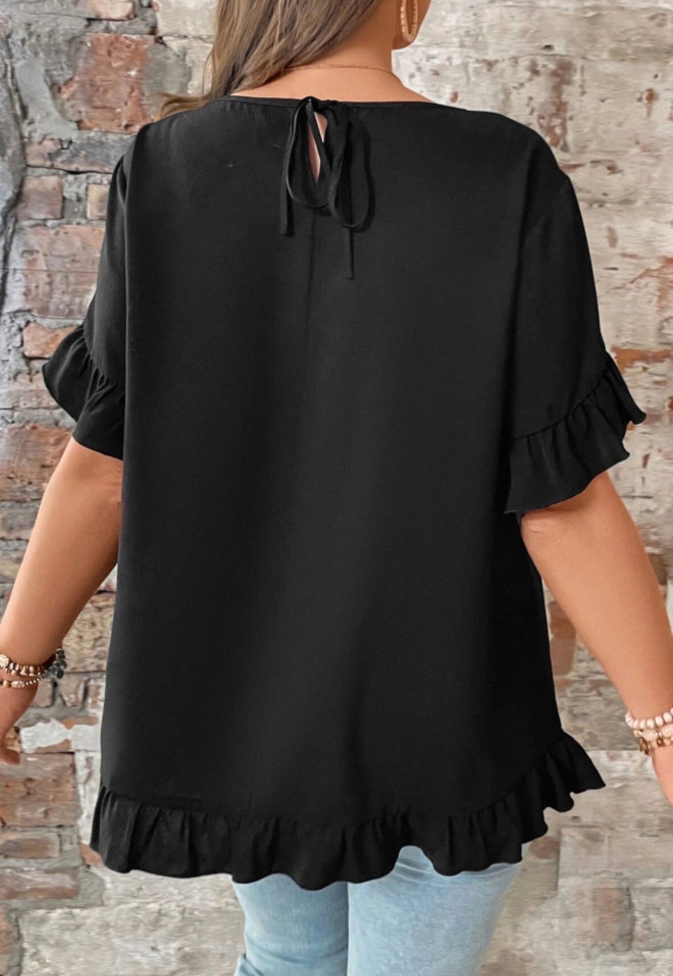 Black ruffle petal sleeve and hem top with tie-back closure, stylish women's blouse from Ivy's Gifts & Boutique.