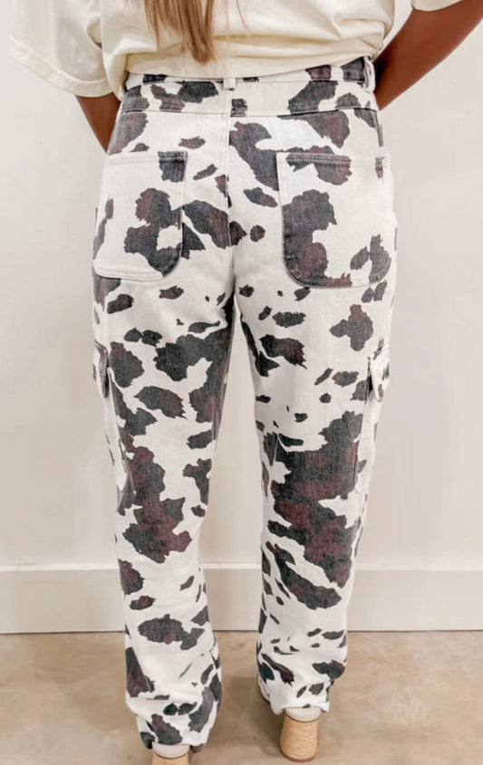 Cow print cargo pants featuring a stylish design by Ivy's Gifts & Boutique, with visible pockets and a trendy look.