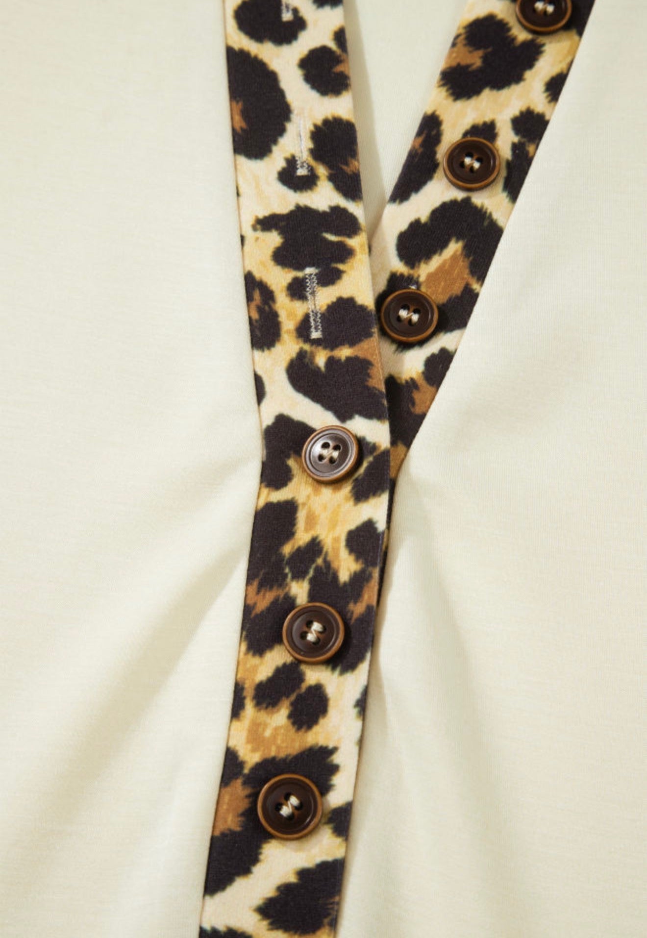 Ivy's Gifts & Boutique animal print trimmed short sleeve button-neck top featuring a stylish neckline and vibrant design.