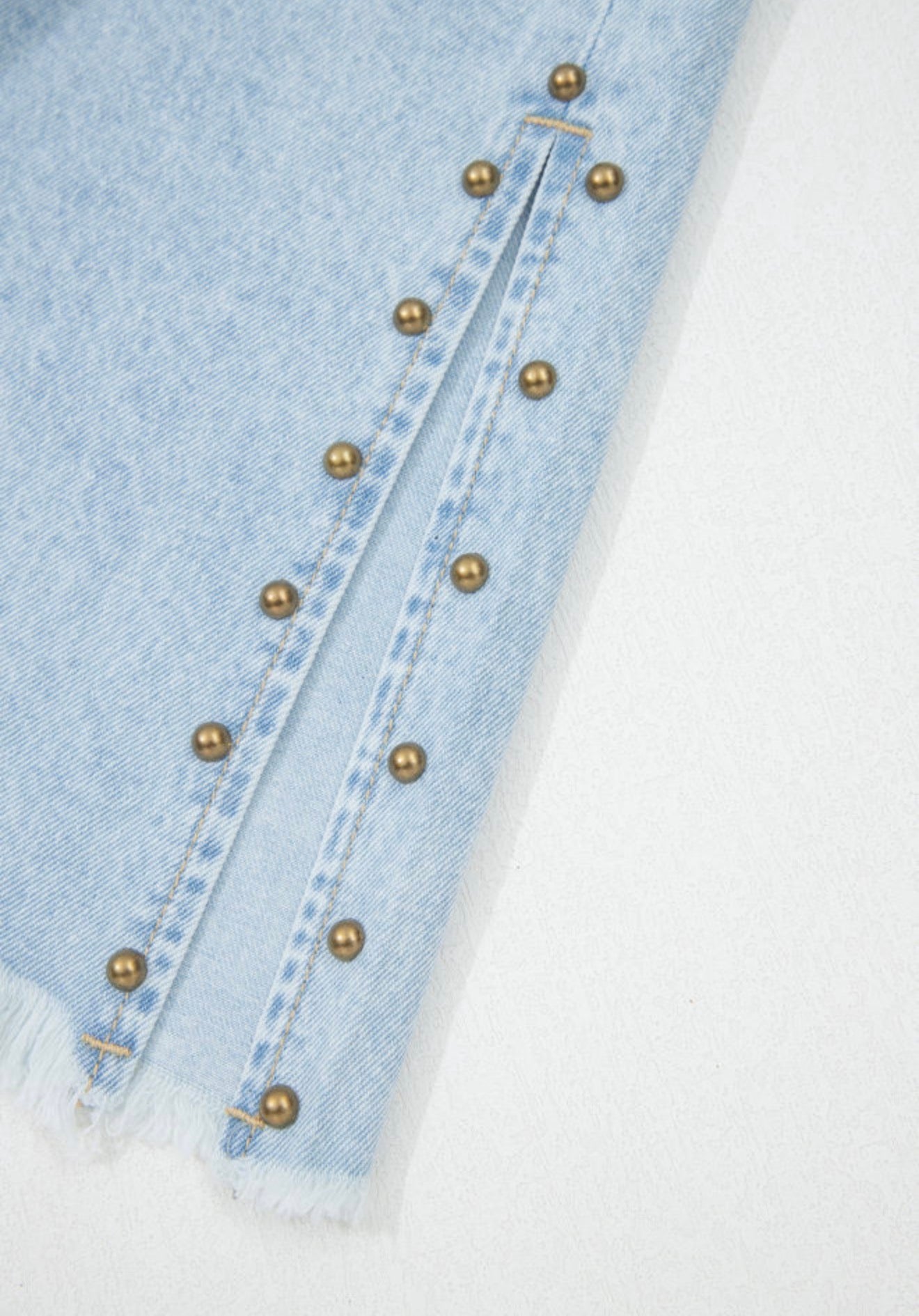 Light wash wide-leg jeans with frayed hems, side splits, and studded accents from Ivy's Gifts & Boutique.