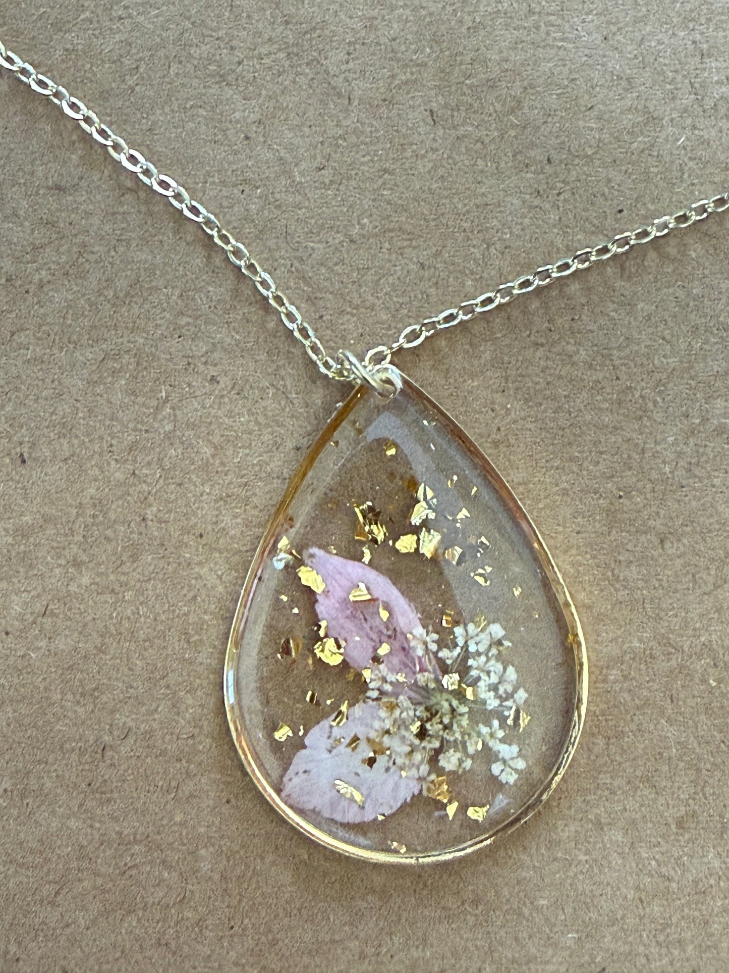 Dried flower pendant necklace by Ivy's Gifts & Boutique featuring a delicate floral charm on a silver chain.