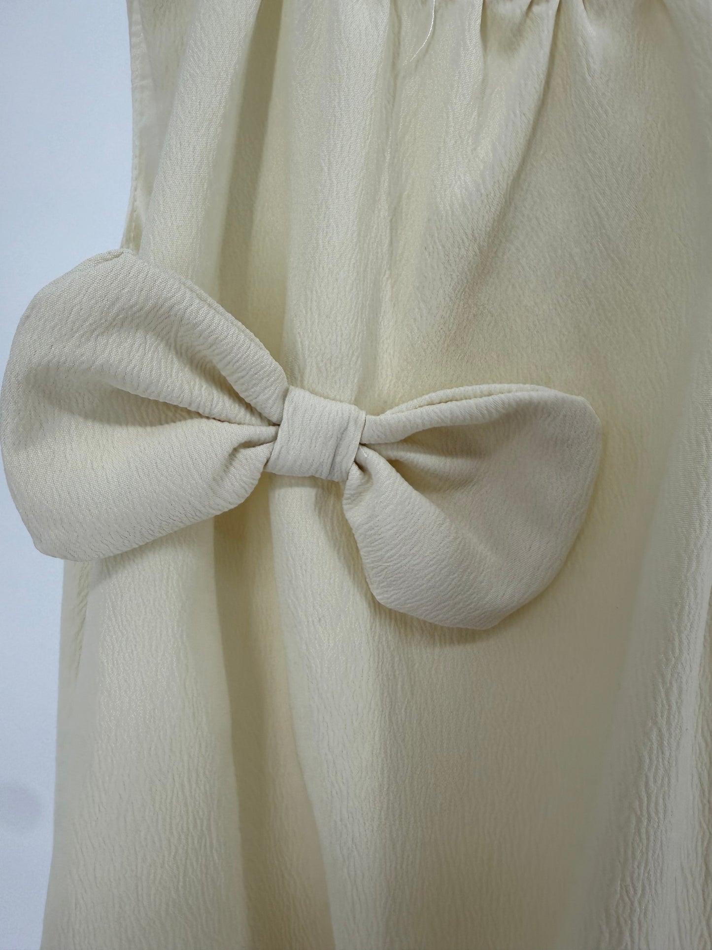 Ivory bubble hem dress with bow accents by Ivy's Gifts & Boutique, featuring a playful and stylish design for girls.