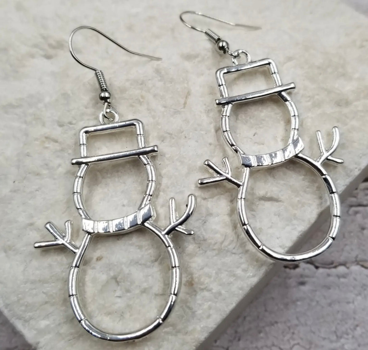 Silver snowman silhouette earrings from Ivy's Gifts & Boutique featuring festive winter design.