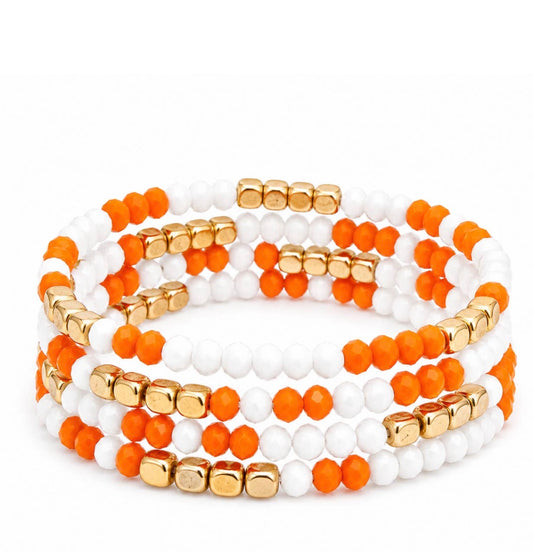 Stack of four TN55 Game Day beaded bracelets in orange, white, and gold from Ivy's Gifts & Boutique, featuring colorful beaded designs.