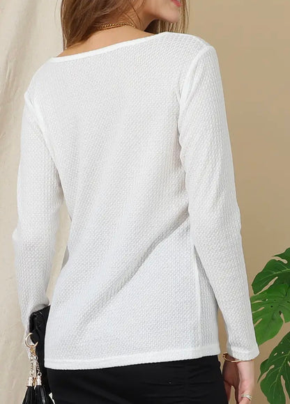 White textured fabric V-neck long sleeve top by Ivy's Gifts & Boutique, showcasing the fabric detail and V-neck design.