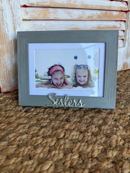 Gray distressed SISM Sisters photo frame with metal script embellishment, fits 4x6 or 5x7 photos, from Ivy's Gifts & Boutique.