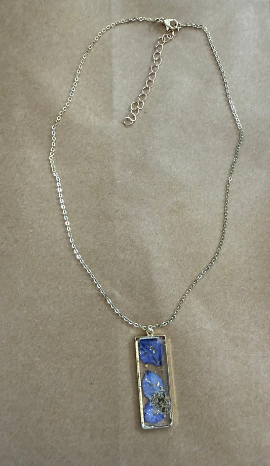 Purple dried flower pendant necklace from Ivy's Gifts & Boutique featuring a delicate floral charm on a silver chain.