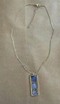 Purple dried flower pendant necklace from Ivy's Gifts & Boutique featuring a delicate floral charm on a silver chain.