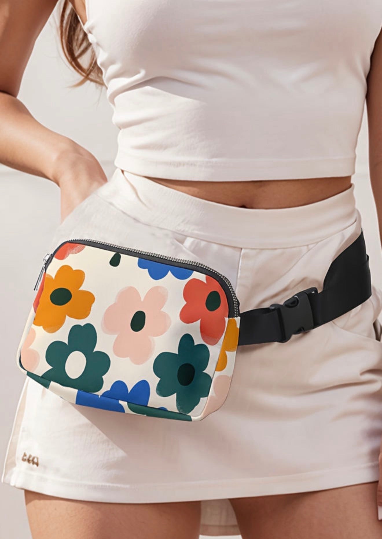 Cute flower printed vinyl cross body fanny pack from Ivy's Gifts & Boutique showing colorful floral design and adjustable strap.