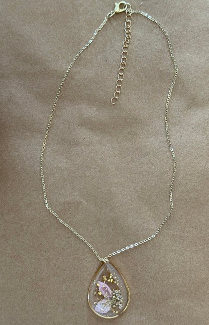 Dried flower pendant necklace with a delicate floral design, featuring a glass or resin setting, from Ivy's Gifts & Boutique.