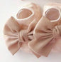 Baby's ivory BT1 infant gripper sock with adorable toe bow embellishment, soft and stretchy for comfortable wear.