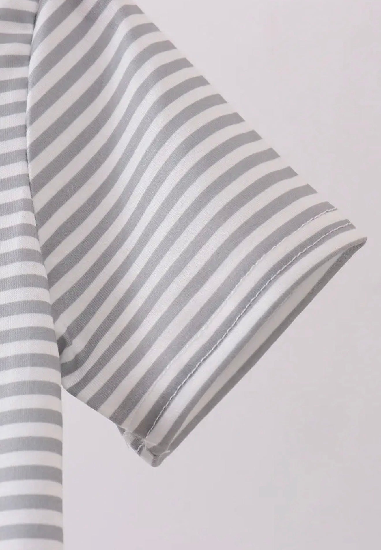 TN1 stripe polo shirt from Ivy's Gifts & Boutique featuring smokey embroidery and classic polo style in a close-up shot.