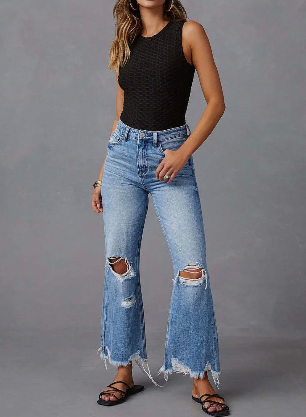 Light wash wide leg distressed jeans with fray hem from Ivy's Gifts & Boutique, showcasing a relaxed fit and trendy distressed details.