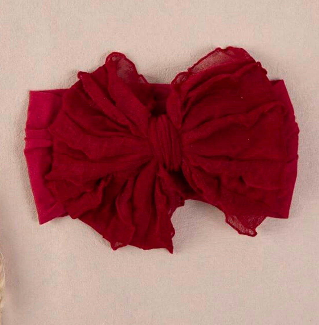 Soft pink infant headband with a bow from Ivy's Gifts & Boutique, perfect for babies and newborns.