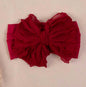 Soft pink infant headband with a bow from Ivy's Gifts & Boutique, perfect for babies and newborns.