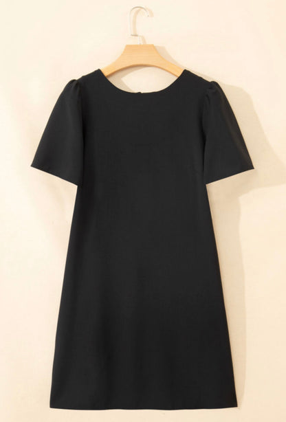 Elegant black dress from Ivy's Gifts & Boutique featuring a stylish back bow detail and convenient pockets.