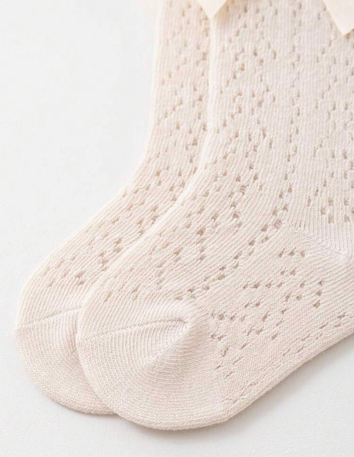 Baby knee socks by Ivy's Gifts & Boutique with bow detail, soft fabric, and stretchy fit for comfortable infant wear.