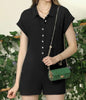 Black romper by Ivy's Gifts & Boutique featuring button front, short sleeves, and wide short legs, displayed on a hanger.