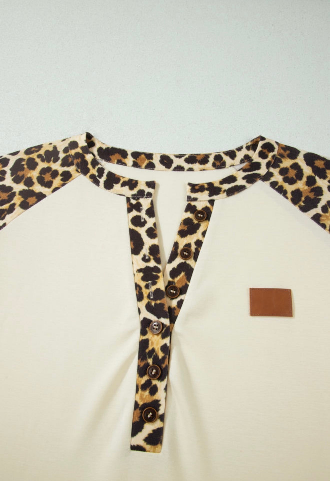 Animal print trimmed short sleeve button blouse from Ivy's Gifts & Boutique with a neckline button closure.