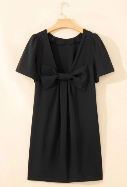 Elegant black dress from Ivy's Gifts & Boutique featuring a stylish back bow and side pockets, perfect for formal occasions.