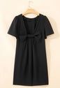 Elegant black dress from Ivy's Gifts & Boutique featuring a stylish back bow and side pockets, perfect for formal occasions.