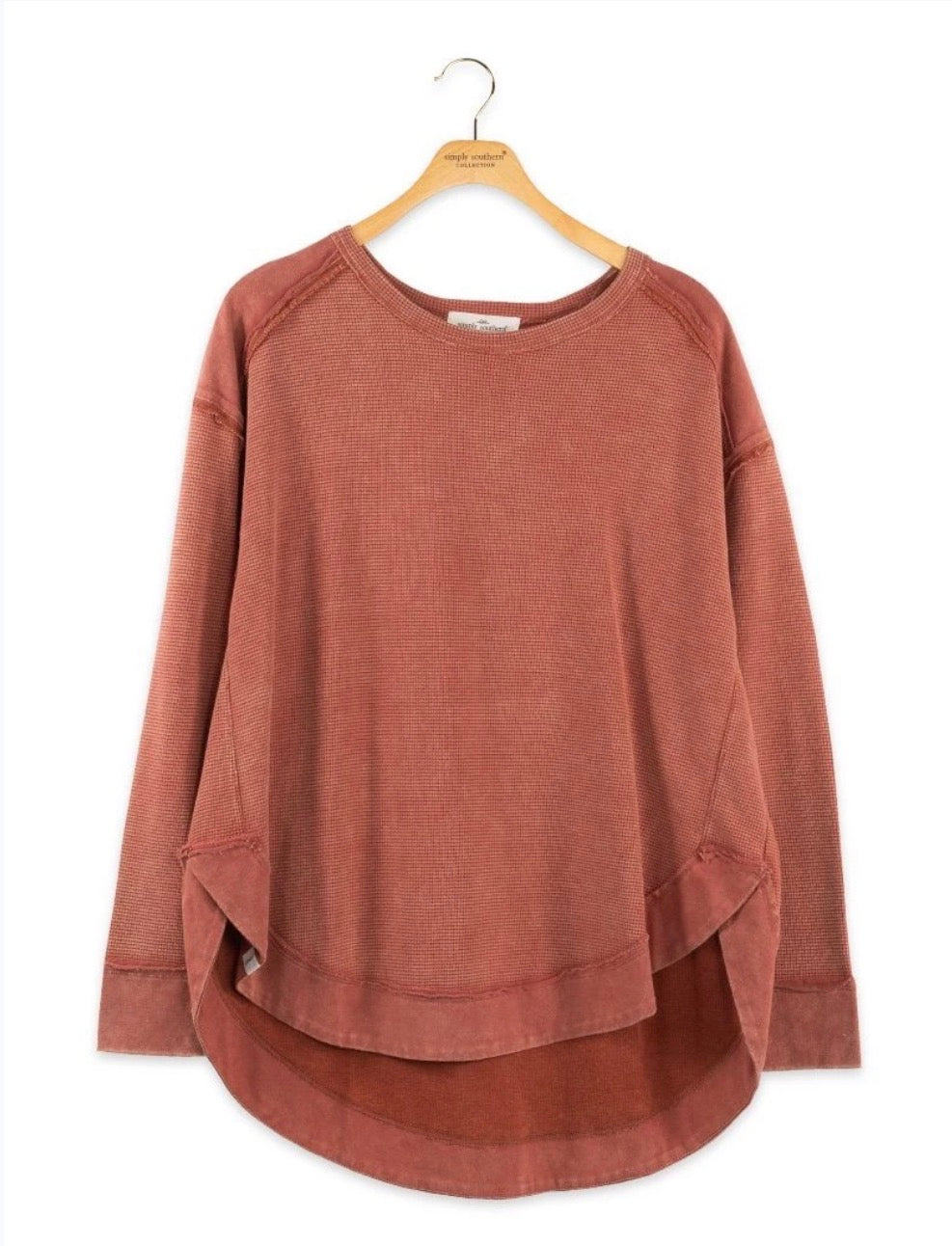 Rust-colored SSWW waffle weave cropped top with exposed seams, styled on a mannequin for a trendy, casual look.