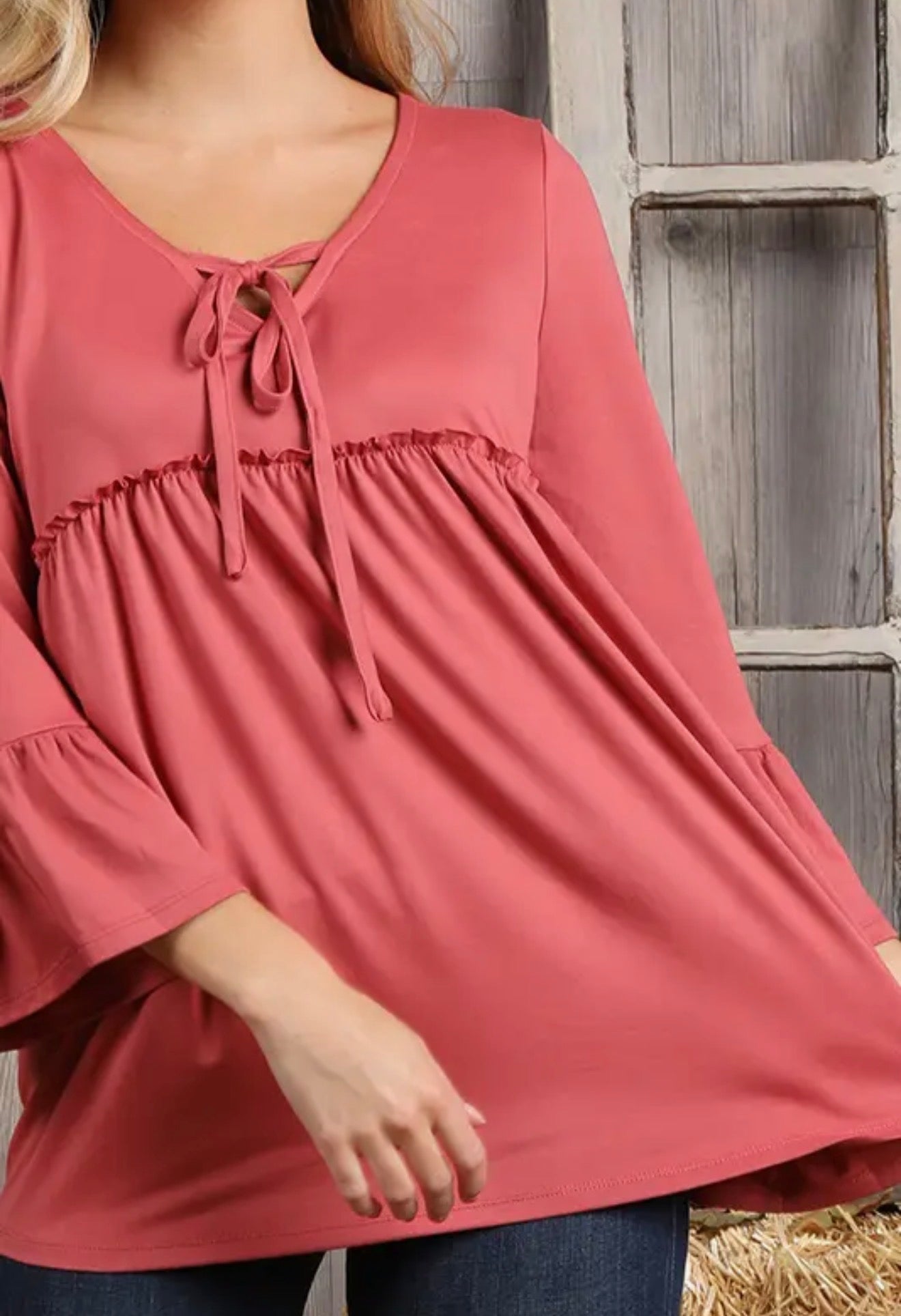 Ivy's Gifts & Boutique solid color top with 3/4 length sleeves and string tie neckline, shown on a hanger.