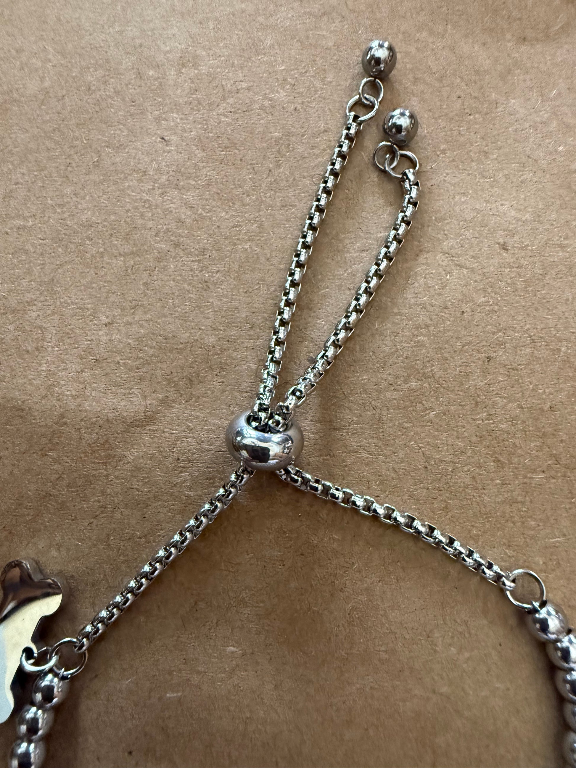 Silver dog bone charm bracelet with adjustable slide closure, featuring Ivy's Gifts & Boutique branding.