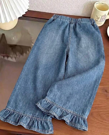 Medium wash denim pants with ruffle hem and pocket details from Ivy's Gifts & Boutique, displayed on a neutral background.