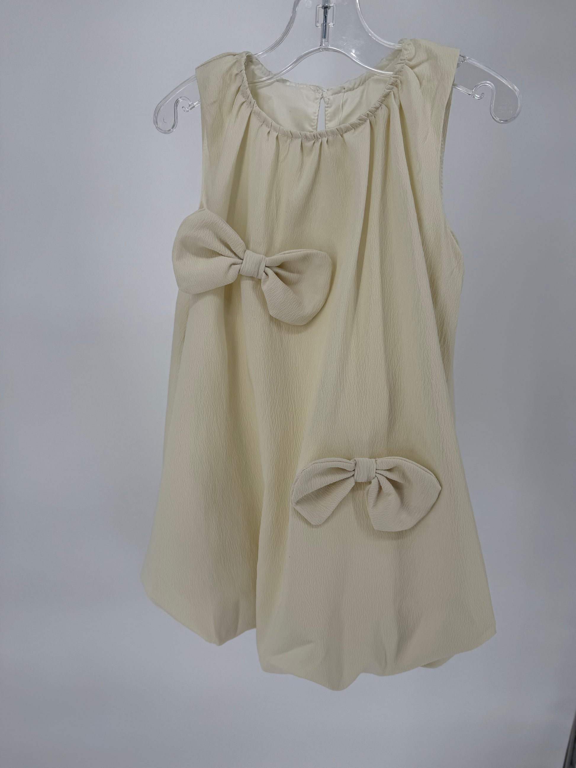 Ivory Bubble Hem Dress with Bow Accents by Ivy's Gifts & Boutique, featuring a stylish and feminine design.